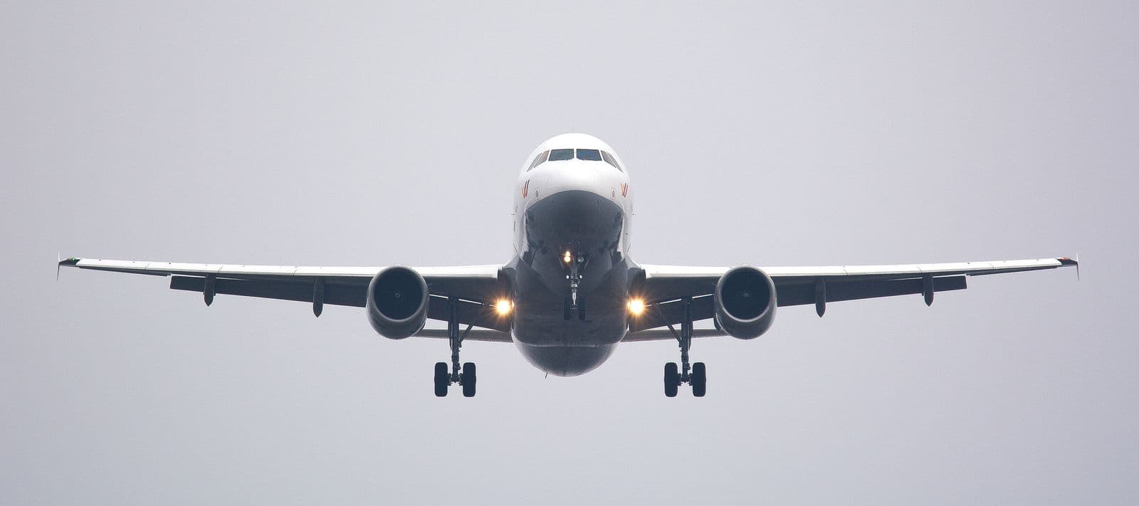 Ein Verkehrsflugzeug im Anflug vor grauem Himmel